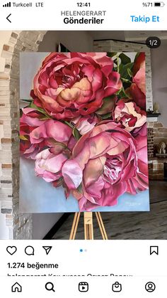 an easel with a painting on it that has pink flowers painted on the canvas