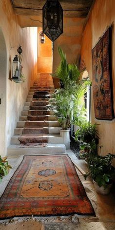 an indoor area with rugs, potted plants and lanterns