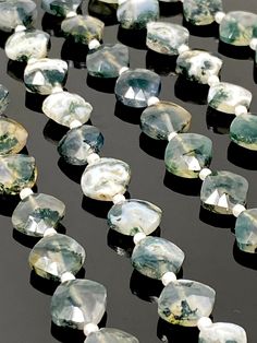 some very pretty green and white stones on a black surface