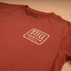 Still's classic stacked logo on our 'Brick Red' Feather Grass tee. Classic Red Fitted T-shirt, Classic Red Cotton T-shirt, Red Classic Cotton T-shirt, Classic Fitted Red T-shirt, Casual Red T-shirt With Branding, Holiday Chaos, Directional Signs, Red Feather, Red S