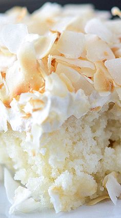 a close up of a piece of cake on a plate with white frosting and toppings