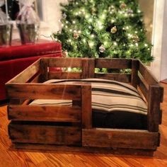 a bed made out of wooden pallets with a christmas tree in the background