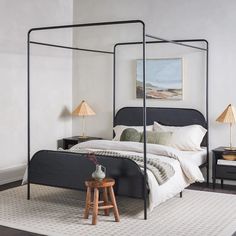 a bedroom with a four post bed and two nightstands on either side of the bed