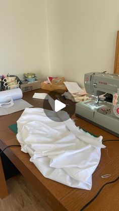 a sewing machine sitting on top of a wooden table next to a piece of cloth