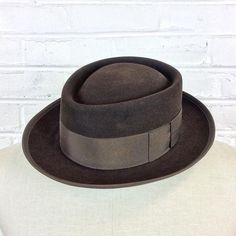 Size 6 7/8 Vintage 1950s 1960s Adam Hats Carbon Brown Porkpie Fedora Hat For your consideration we have a vintage fedora from the ‘50s/‘60s. Made by Adam Hats from a “carbon brown” fur felt, this “Rugby” model features a telescopic crown, brown grosgrain band and edge, leather sweatband, and rayon lining. There are a few spots on the hat band and a few stitches have come out of the leather sweatband. This is still a great hat and wonderful for anyone into slick bop midcentury style.Measurements; Vintage Adjustable Fur Felt Fedora, Fitted Brown Brimmed Top Hat, Fitted Brown Top Hat With Short Brim, Brown Felt Hat With Flat Bill For Formal Occasions, Formal Brown Felt Hat With Flat Bill, Fitted Brown Top Hat With Flat Brim, Brown Fitted Top Hat With Flat Brim, Retro Fitted Fedora With Curved Brim, Retro Fedora With Curved Brim