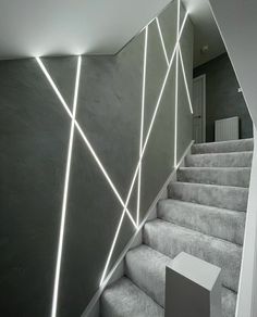 the stairs are lit up with bright lights in this modern home design by studio o'connor