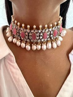 RESTOCKED ♥️ Be your own kind of beautiful. Simply a mark of royalty and elegance! You will definitely fall in love with the beautifully placed pink stones with Kundan Stone embellishments. One of our favourite picks for the wedding season 2021❤️ The pearl drops add a perfect glamour to the gorgeous piece. The pretty statement earrings add to the royalty of the stunning choker necklace. Length of earrings: 5 cms , push back closure The weight of the earrings is 16 g per pair. Pink Jeweled Bridal Necklace For Wedding, Ornate Bridal Necklace With Cutdana For Wedding, Handmade Pink Bridal Necklace For Wedding, Ornate Pink Wedding Jewelry, Elegant Pink Bridal Necklace With Tilla, Elegant Pink Bridal Necklace For Festivals, Elegant Pink Tilla Bridal Necklace, Ornate Handmade Bridal Necklace For Wedding, Elegant Handmade Bridal Necklace For Reception