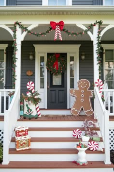 a house decorated for christmas with gingerbreads and candy canes on the front porch