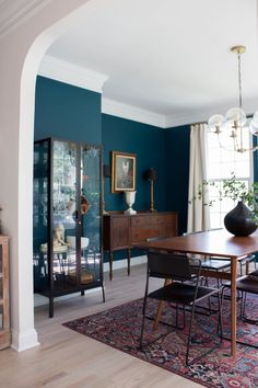 a dining room with blue walls and furniture