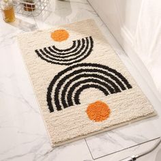 a white rug with black and orange circles on it