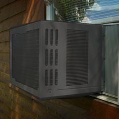 an air conditioner mounted on the side of a house next to a window sill