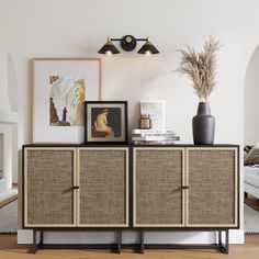 a living room with a couch and some pictures on the wall next to a sideboard