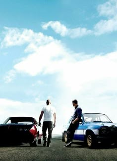 two men are standing next to their cars