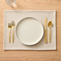 a place setting with silverware on a linen placemat