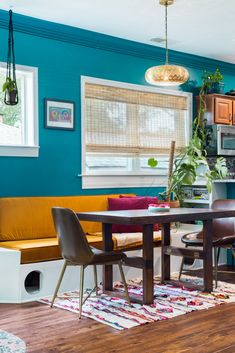 a living room filled with furniture and a wooden table in front of a blue wall