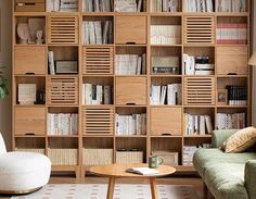 a living room filled with lots of wooden bookshelves next to a green couch