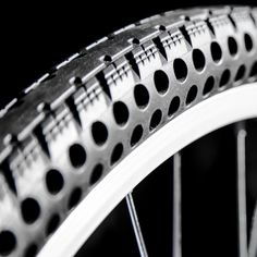 a close up view of a bicycle tire on a black background with white spokes