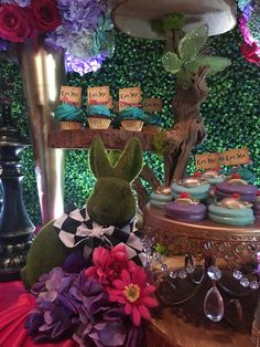 a table topped with cupcakes and cakes covered in frosting