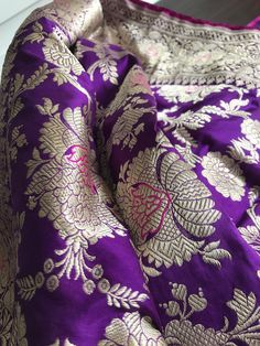 This is an authentic handloom kadhuwa jungla floral jaal banarasi saree woven in double katan silk. This splendid saree woven in purple colour is truly breathtaking!!Floral jaal woven in kadwa weave, which requires more skill and takes much longer to weave, makes this saree truly special. The meenakari floral motifs against the purple tone shines like an embossed jewel. Saree has fuschia pink selvedge on the borders which gives the subtle contrast. The same fuschia pink tone is used to accentuat Luxury Purple Banarasi Silk Pre-draped Saree, Luxury Purple Katan Silk Pre-draped Saree, Traditional Purple Jamawar Wear, Purple Jamawar Traditional Wear For Diwali, Purple Jamawar Dupatta With Zari Work, Purple Banarasi Silk Traditional Wear With Pallu, Unstitched Traditional Purple Saree, Traditional Unstitched Purple Saree, Purple Tussar Silk Traditional Wear With Pallu