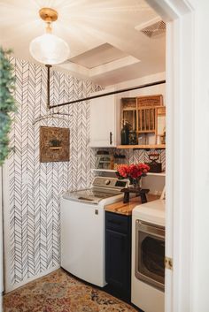 a washer and dryer sitting in a kitchen next to a wall with arrows on it