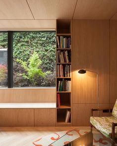 a living room filled with furniture and a book shelf next to a large open window