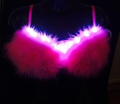 a bra that is glowing in the dark with pink fur on it's chest