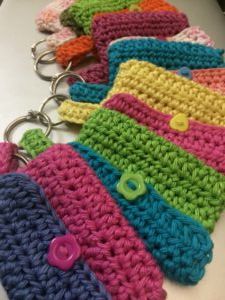 several crocheted purses are lined up on a table with buttons in them