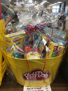 a large yellow basket filled with toys and other items for sale in a toy store