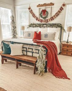 a bedroom decorated for christmas with red, white and green decor