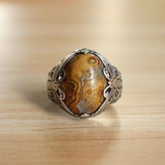 This size 6.75 lace agate eye ring is one-of-a-kind with unique butterfly casts.  Lace agate is a stone said to ward off evil. It is a birthstone of May and June and is an astrological stone of Gemini.  Sterling silver is hypoallergenic and safe for those with sensitive skin.  DIMENSIONS:  Band width: 3.5 millimeters Lace agate dimensions: 17.0 millimeters x 14.0 millimeters  Weight: 5.3 grams Please note that vintage jewelry is pre-loved and might have minor imperfections as seen in the listing Vintage Rings With Natural Stones For Healing, Vintage Agate Gemstone Rings, Brown Oval Agate Rings, Bohemian Oval Agate Rings, Oval Brown Agate Rings, Luxury Engraved Agate Rings, Unique Oval Agate Rings, Vintage Oval Agate Ring, Vintage Agate Jewelry With Large Stone