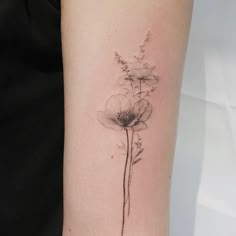 a single flower tattoo on the arm