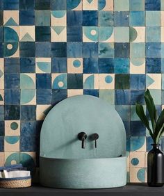 a blue sink sitting on top of a counter next to a vase and potted plant