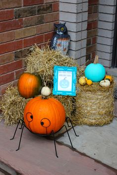 pumpkins and hay bales are sitting on the front porch with decorations around them