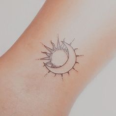 a small sun and moon tattoo on the wrist