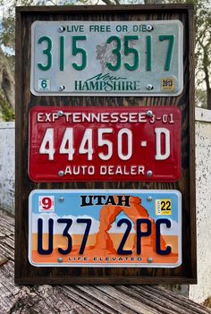 three license plates are stacked on top of each other in front of a wooden bench