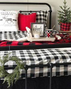 a black and white checkered bed spread with christmas decorations on the headboard next to it