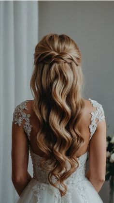 the back of a woman's head with long, wavy hair in her wedding dress