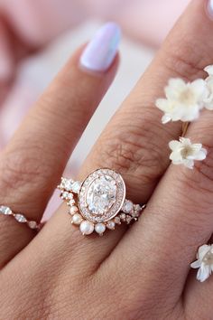 a woman's hand with two rings and flowers on it