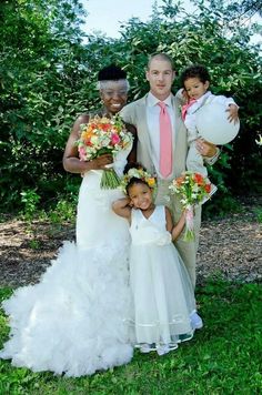 a man and two women are posing for a photo with their children on their wedding day