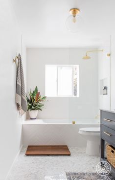 a bathroom with a toilet, sink and bathtub next to a window on the wall