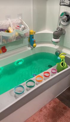 a bathtub filled with lots of toys in a bathroom