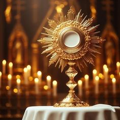 a golden cross on top of a table with candles in the background