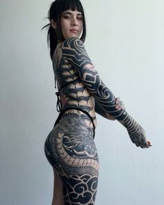 a woman with tattoos on her back and arms