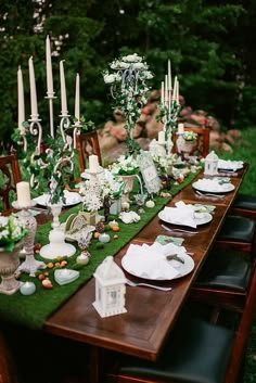 a long table with candles and plates on it