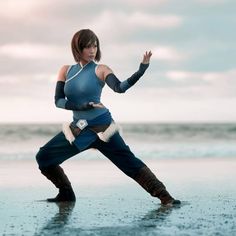 a woman in blue is standing on the beach