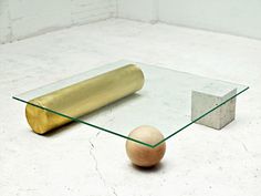 an egg sitting on top of a glass table next to a roll of gold foil