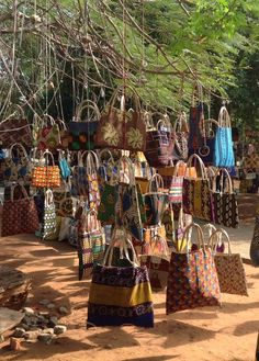 many purses are hanging up in the dirt