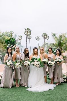 the bride and her bridesmaids pose for a photo in front of palm trees