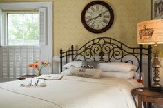 a bedroom with a large bed and clock on the wall