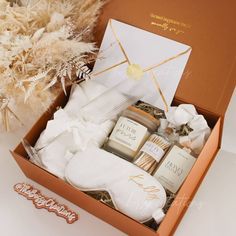 an open box containing personal care items on a white surface with dried plants in the background